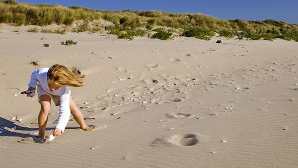 Een meisje is aan het spelen op het strand nabij onze camping in Schouwen-Duiveland.