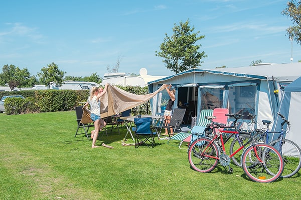 Een gezin is hun tent aan het opbouwen op onze camping in Schouwen-Duiveland.